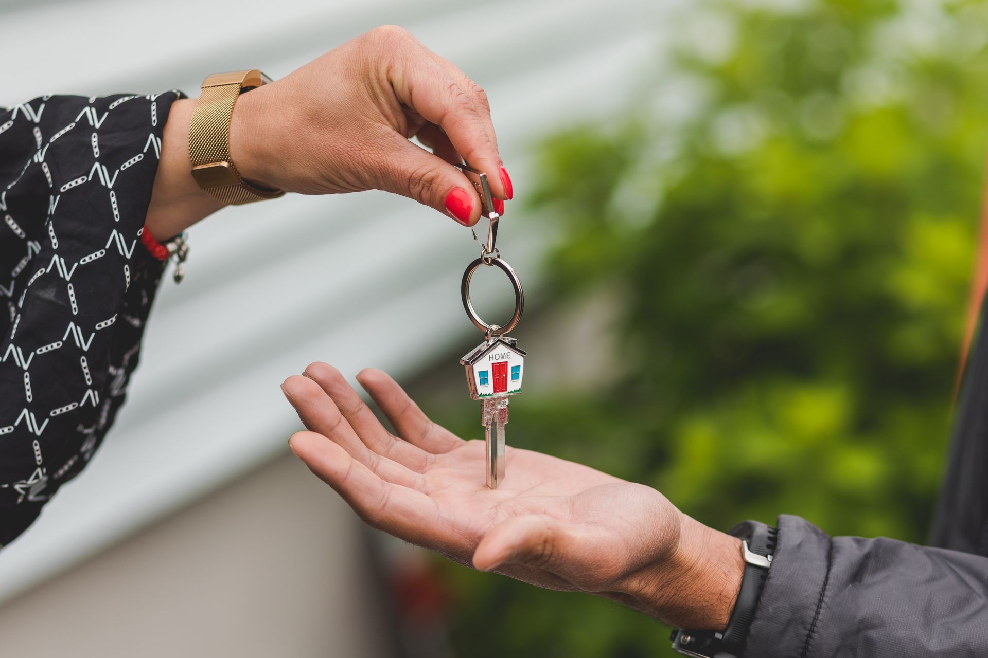 hands handing a house key